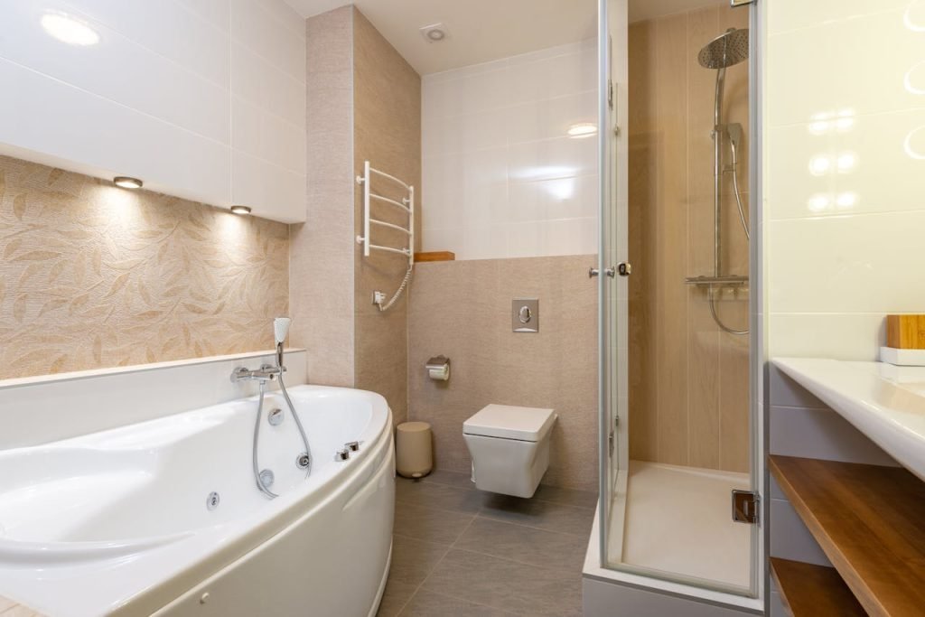 A contemporary bathroom featuring a bathtub, shower, and elegant design elements.